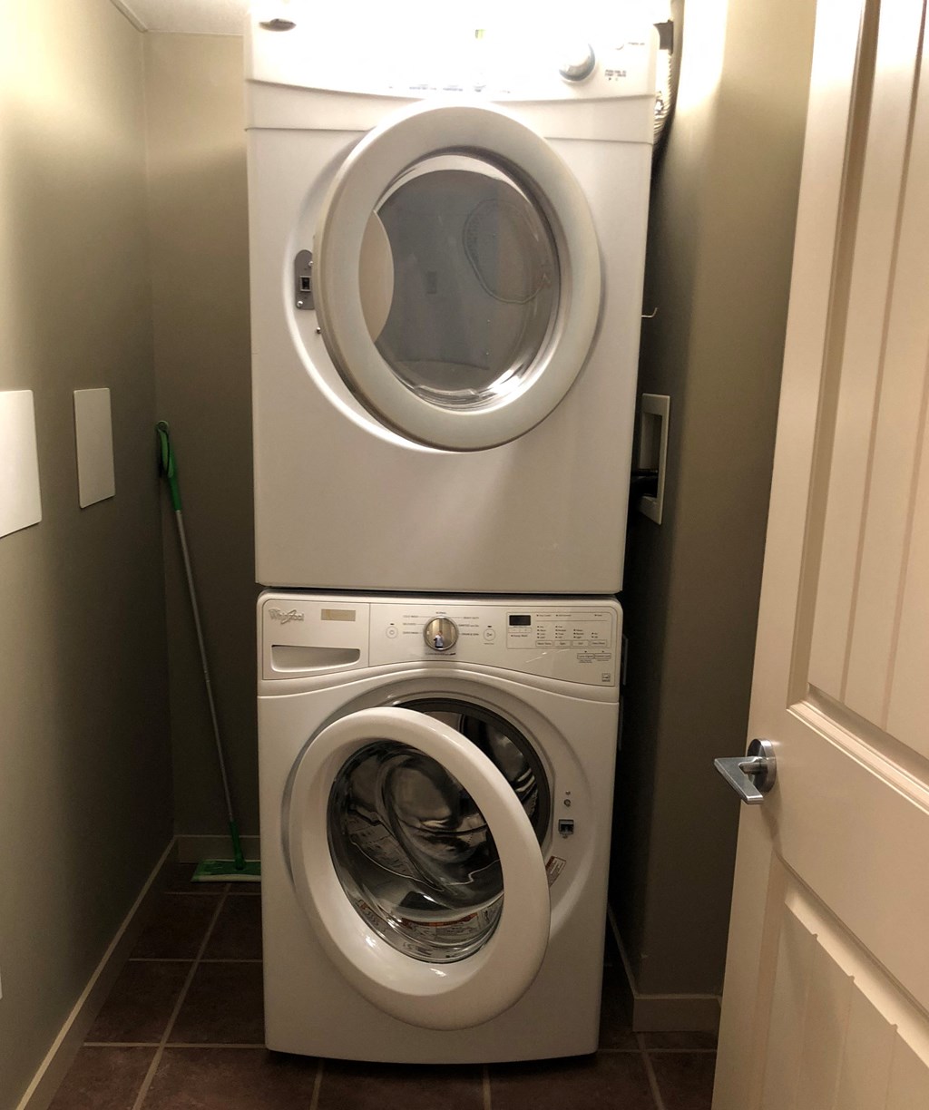 A white dryer and washer in a small laundry room.