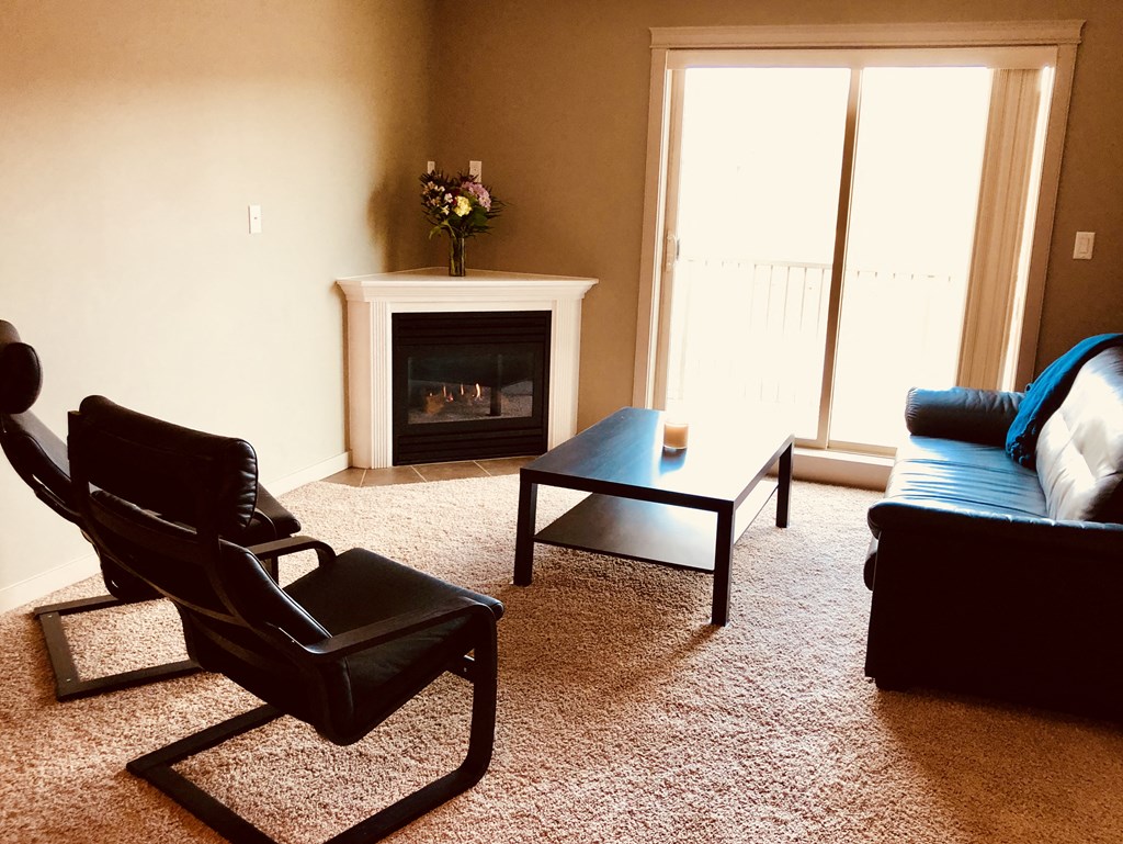 A living room with a fireplace and a chair.