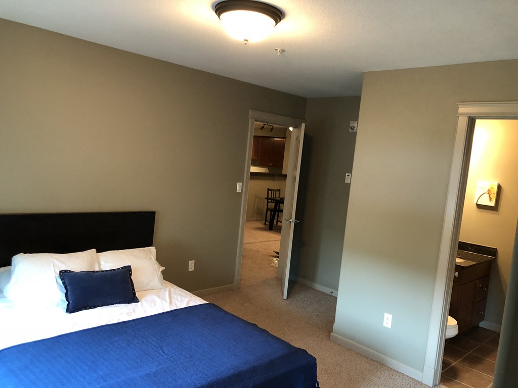 A bedroom with a bed and a blue bedspread.