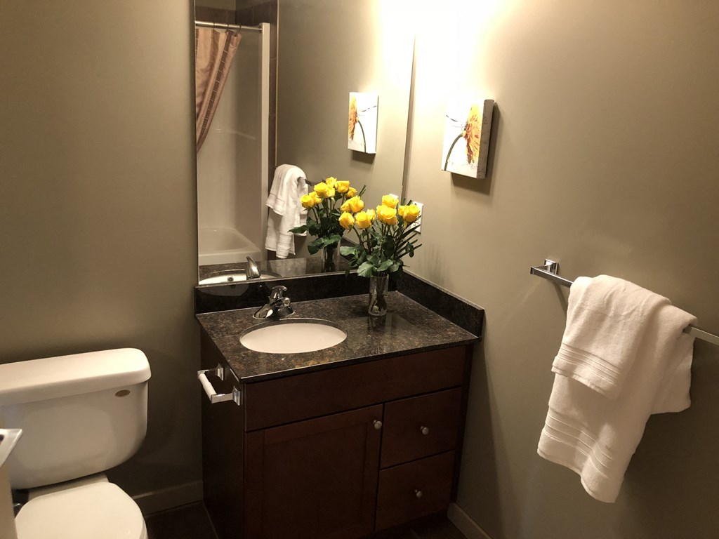 A white towel hangs on a towel rack in a bathroom.