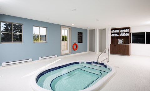 a whirlpool tub in the center of a large room with a blue wall