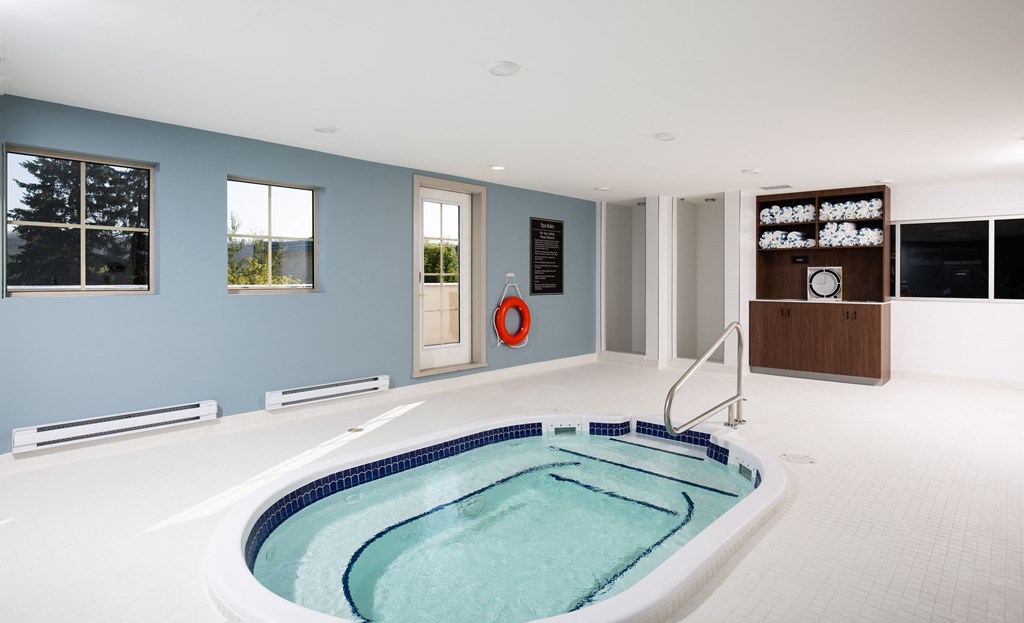 a whirlpool tub in the center of a large room with a blue wall