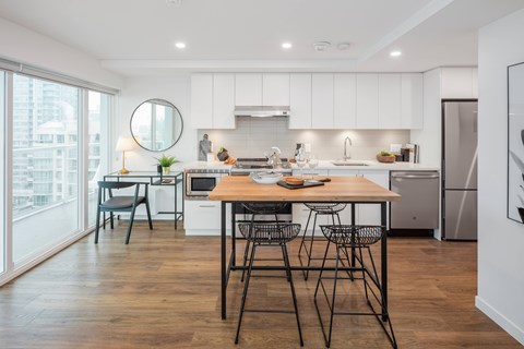 A modern kitchen with a dining table and chairs.