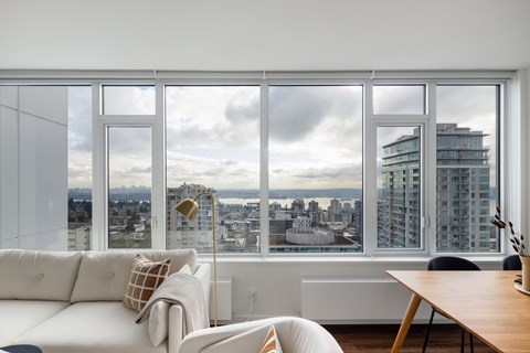 A modern living room with a view of the cityscape outside the large window.