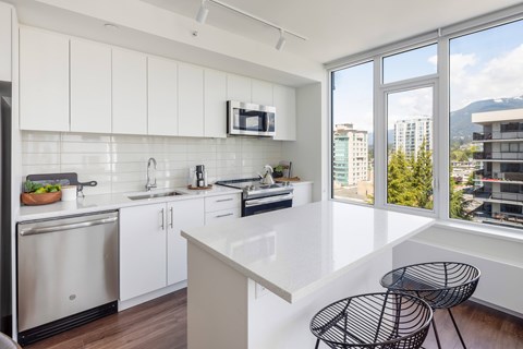 A modern kitchen with white cabinets and a large island.