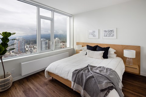 A bedroom with a large bed and a view of the city.
