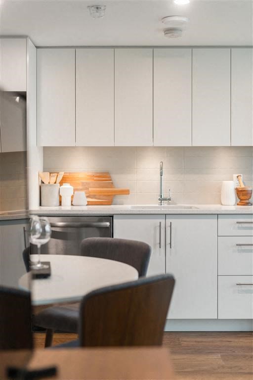a kitchen with white cabinets and a table and chairs