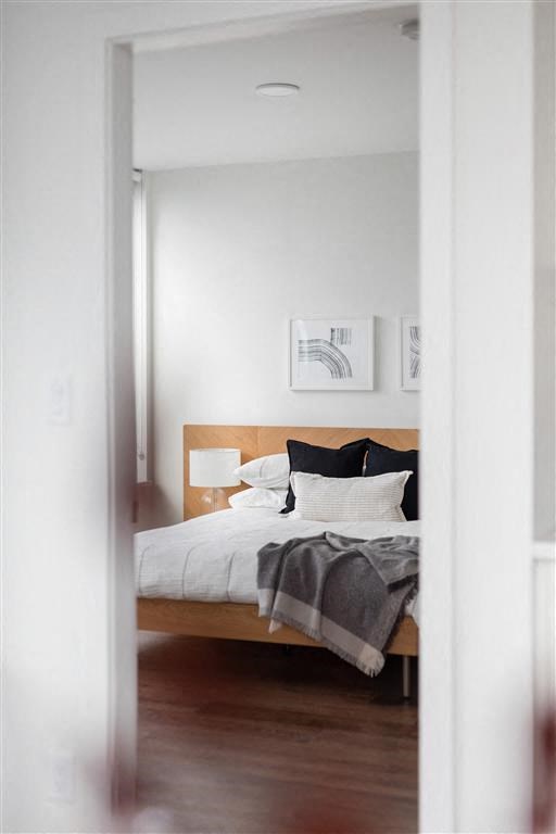 a bedroom with a bed and a wood floor