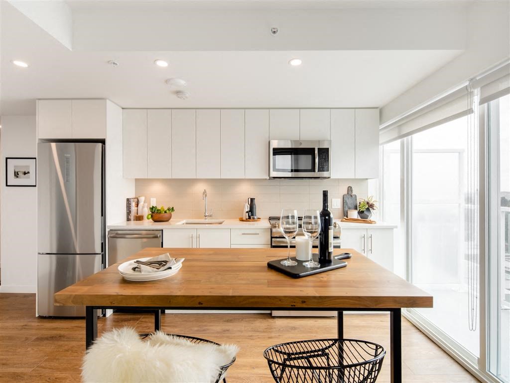 a kitchen with a table and a refrigerator