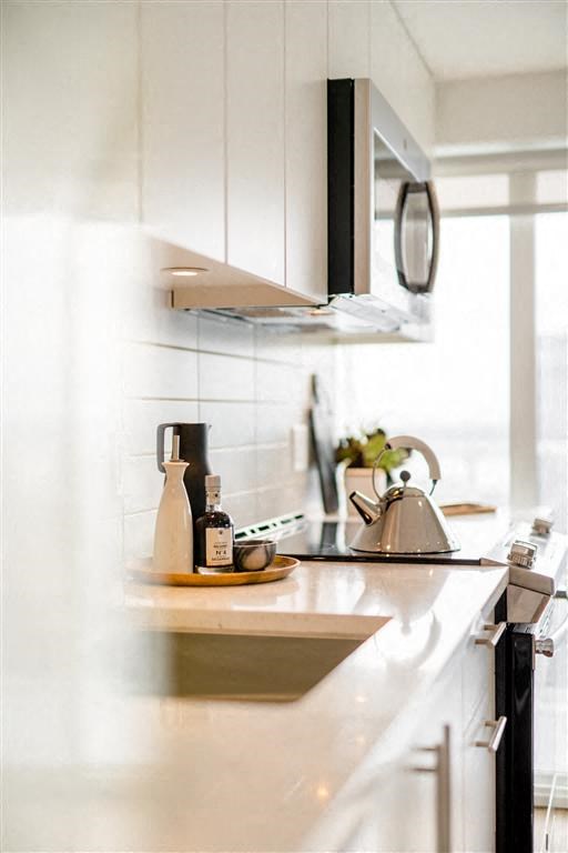a white kitchen with a sink and a microwave