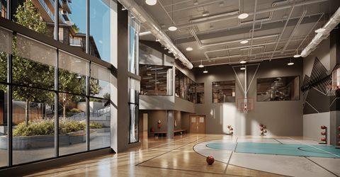A basketball court is located in the middle of a spacious room.