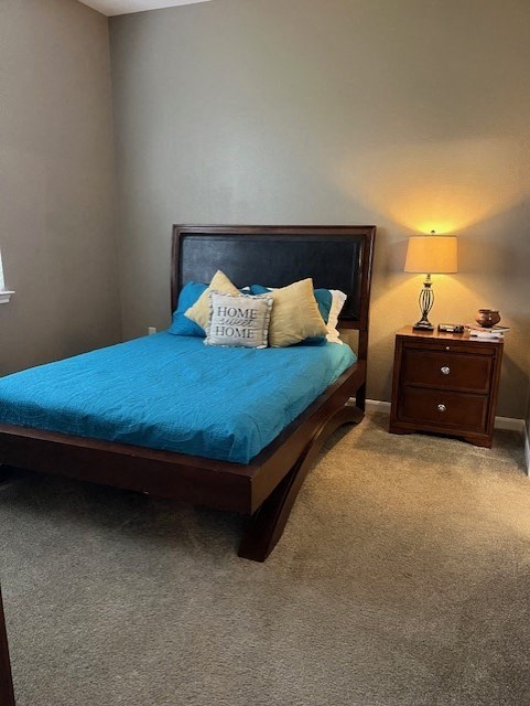 a bedroom with a bed with a blue comforter and pillows