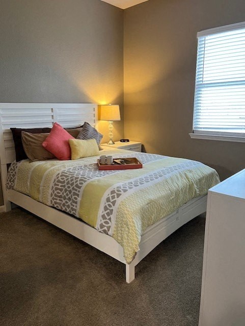 a bedroom with a bed and a table and a window