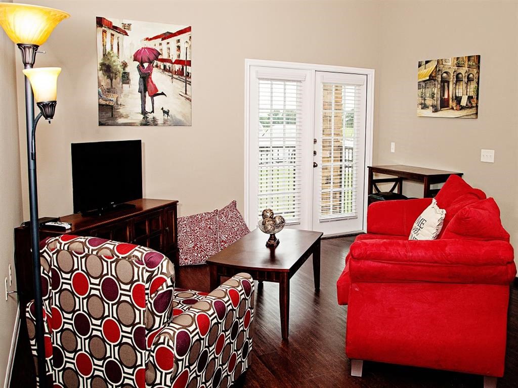 a living room with a red couch and a table