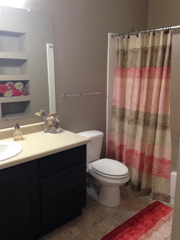 a bathroom with a toilet and a sink and a shower curtain