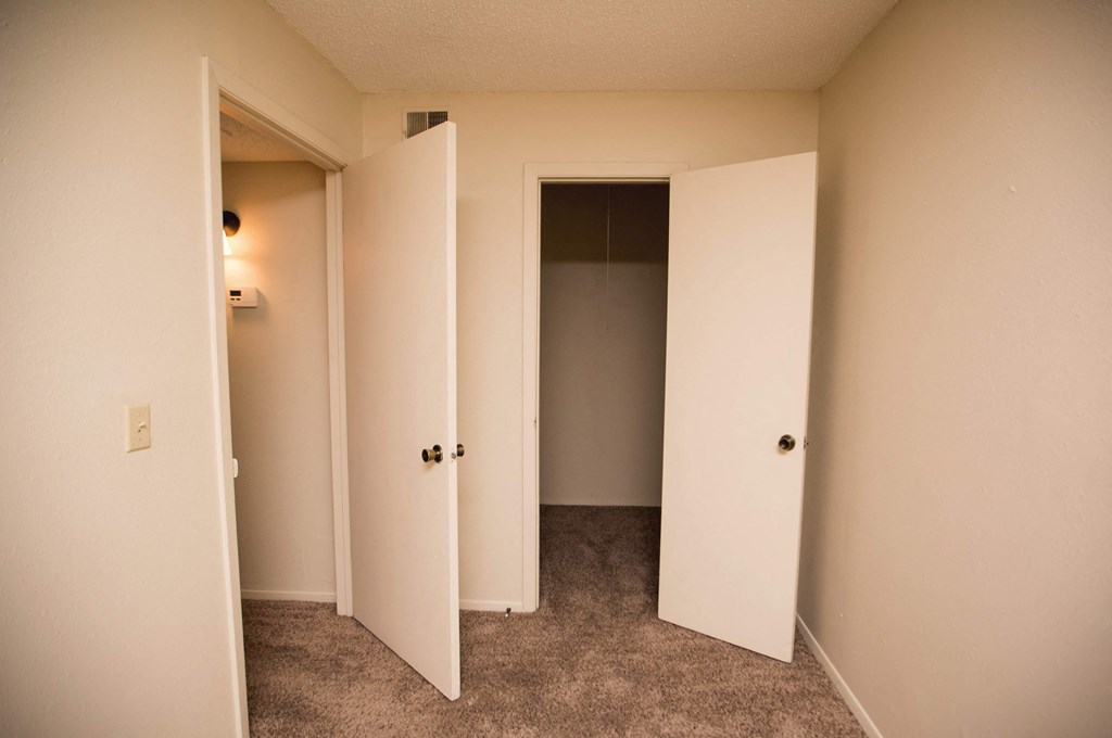 a bedroom with three closets and a door to a closet