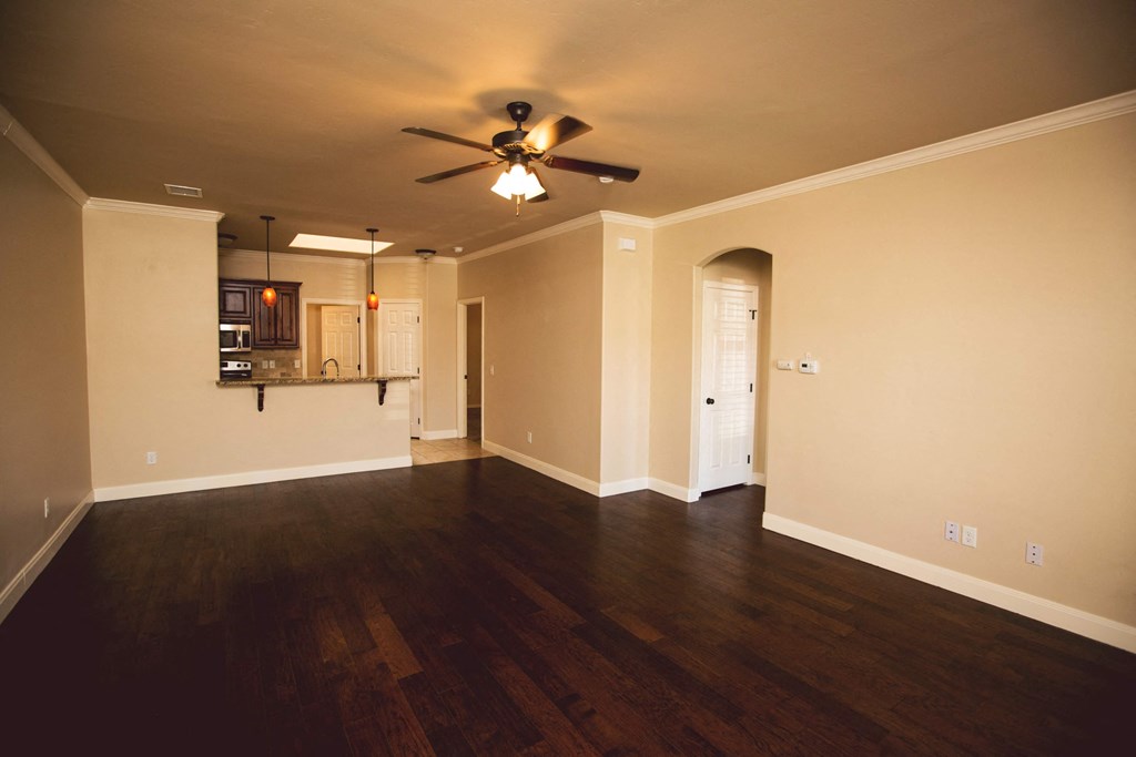 an empty living room with a ceiling fan