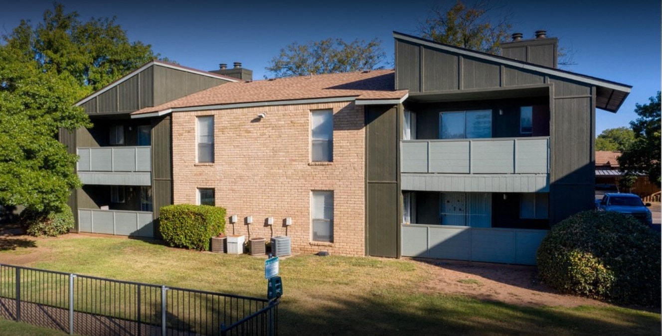 a house with a yard in front of a fence