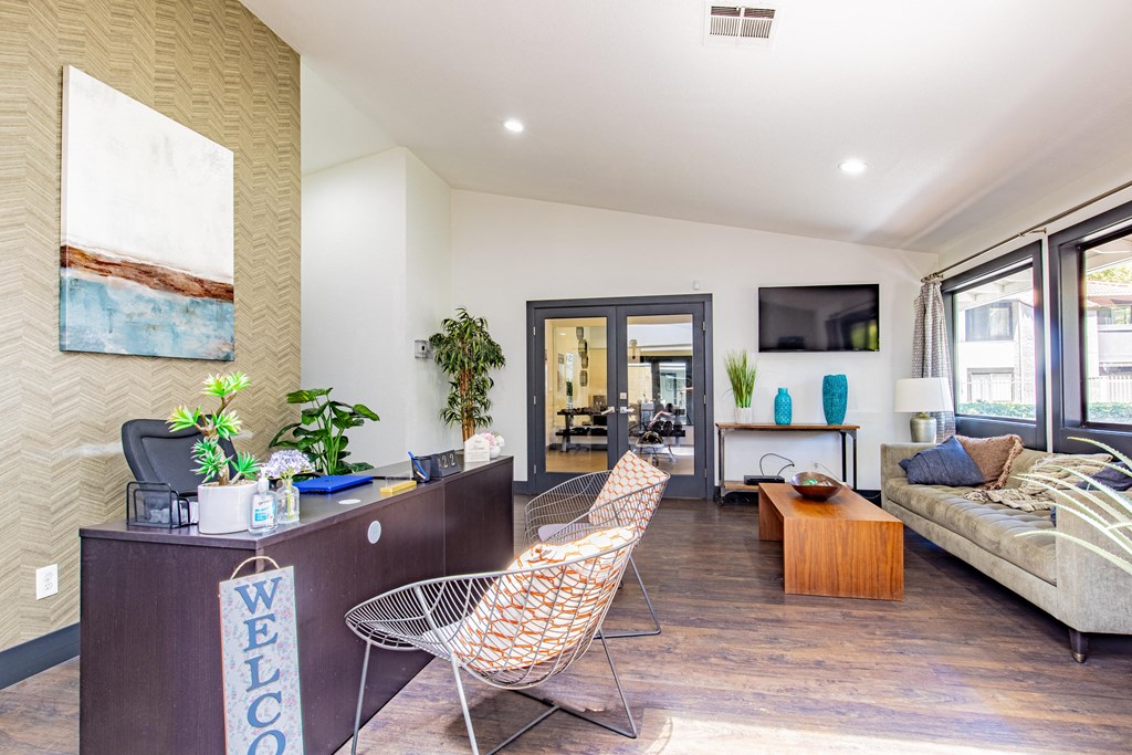 a living room with a desk and chairs
