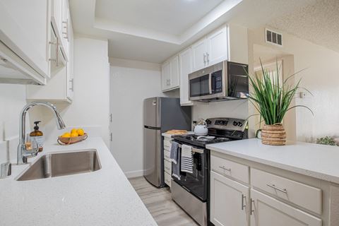 a kitchen with white cabinets and stainless steel appliances  at Metro 3610, Riverside, 92505
