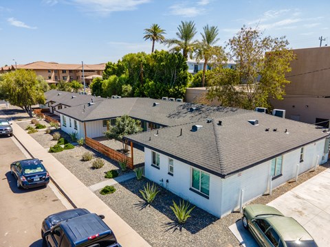 an aerial view of a row of houses with cars parked in front of them