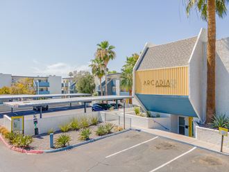a parking lot with a yellow and blue building with the words arcadia on it