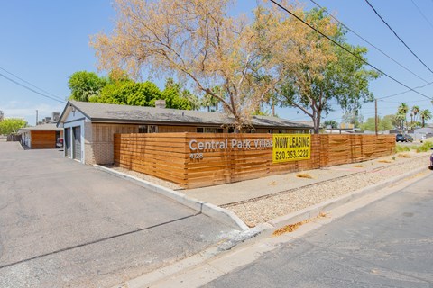 a wooden fence in front of a building with a yellow sign that says central pacific nursing