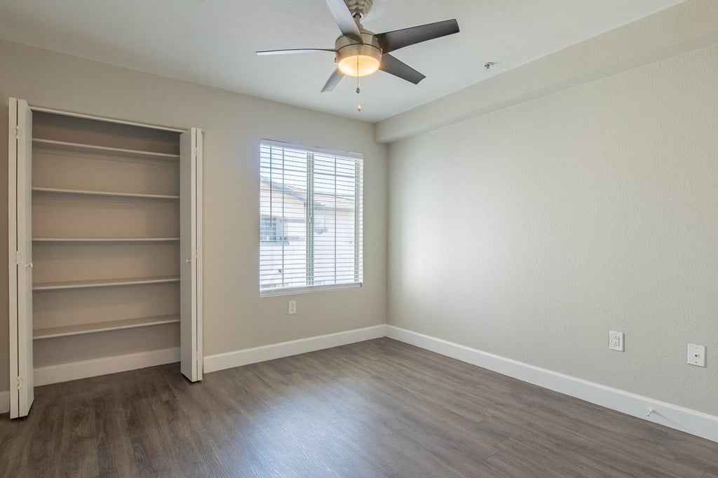 a bedroom with a ceiling fan and a window