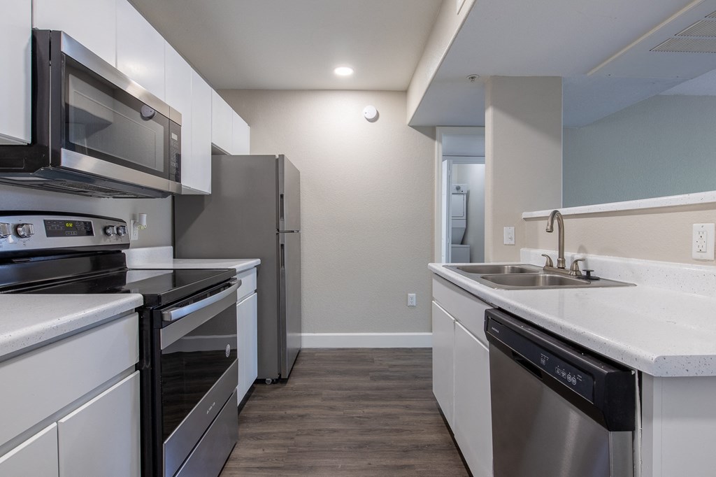 a kitchen with white cabinets and stainless steel appliances