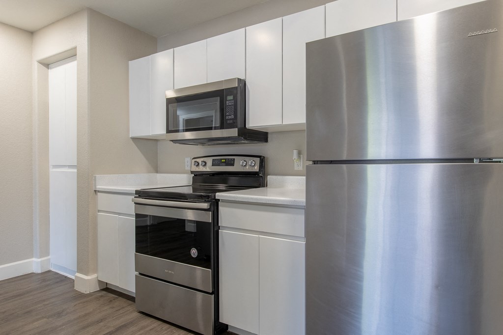 a kitchen with white cabinetry and stainless steel appliances