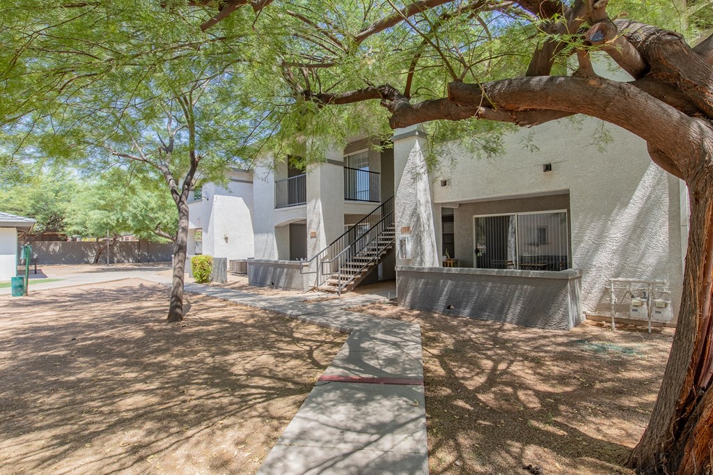a building with a staircase and trees in front of it