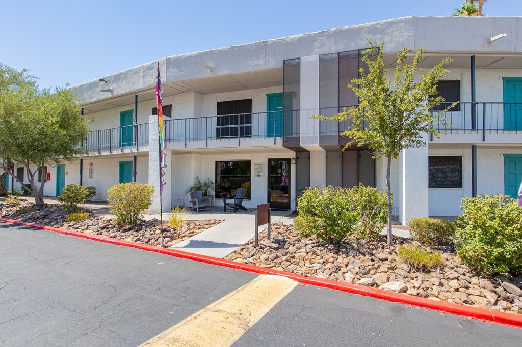 a white building with blue shutters and a yellow line in front of it
