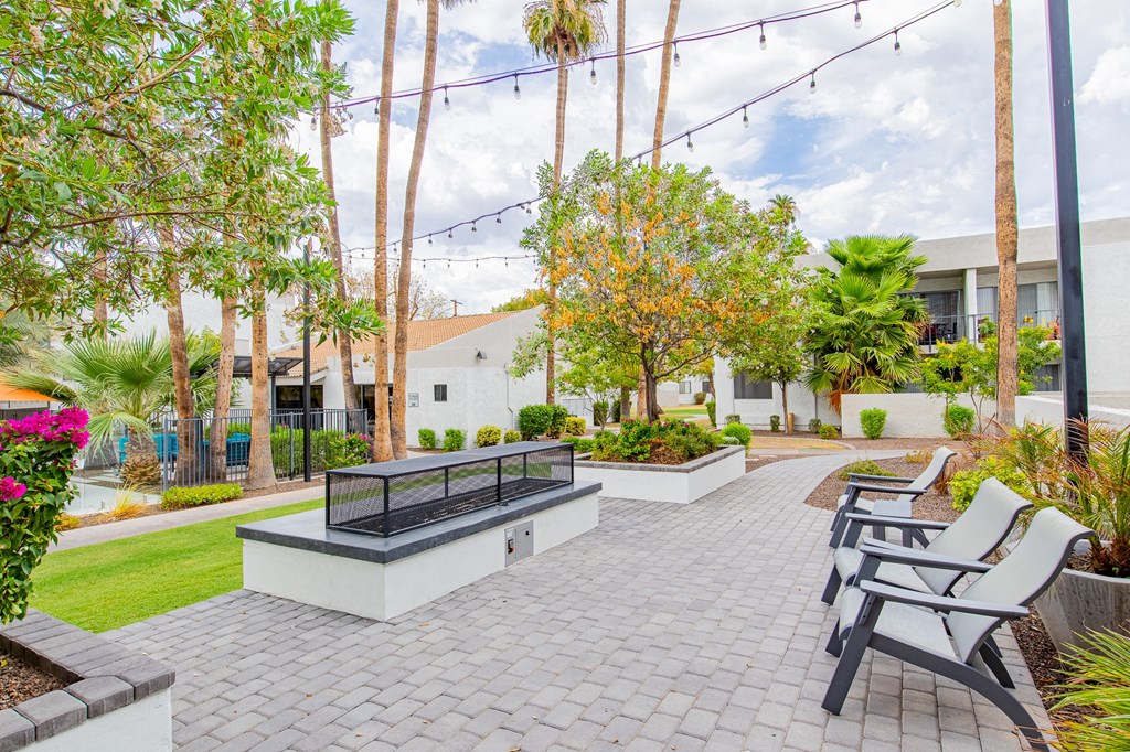 a patio with chairs and a fire pit