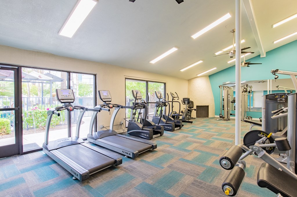 the gym with cardio equipment at the community center apartments