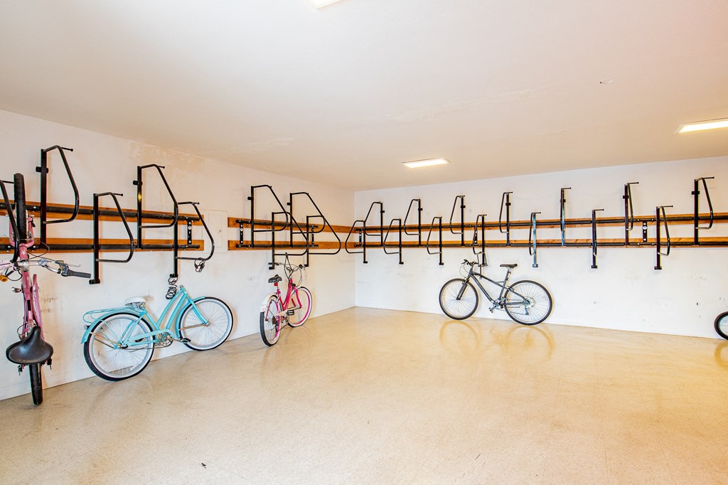 a room with several bikes hanging on a wall and a bike rack on the wall