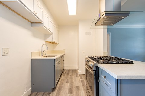 A kitchen with a stove top oven and a sink.