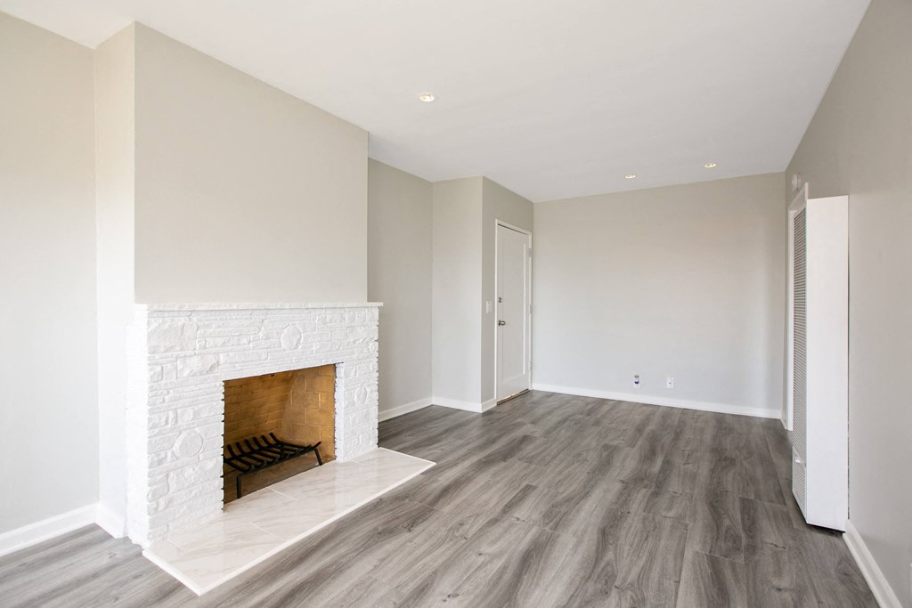 a living room with a fireplace and wooden floors