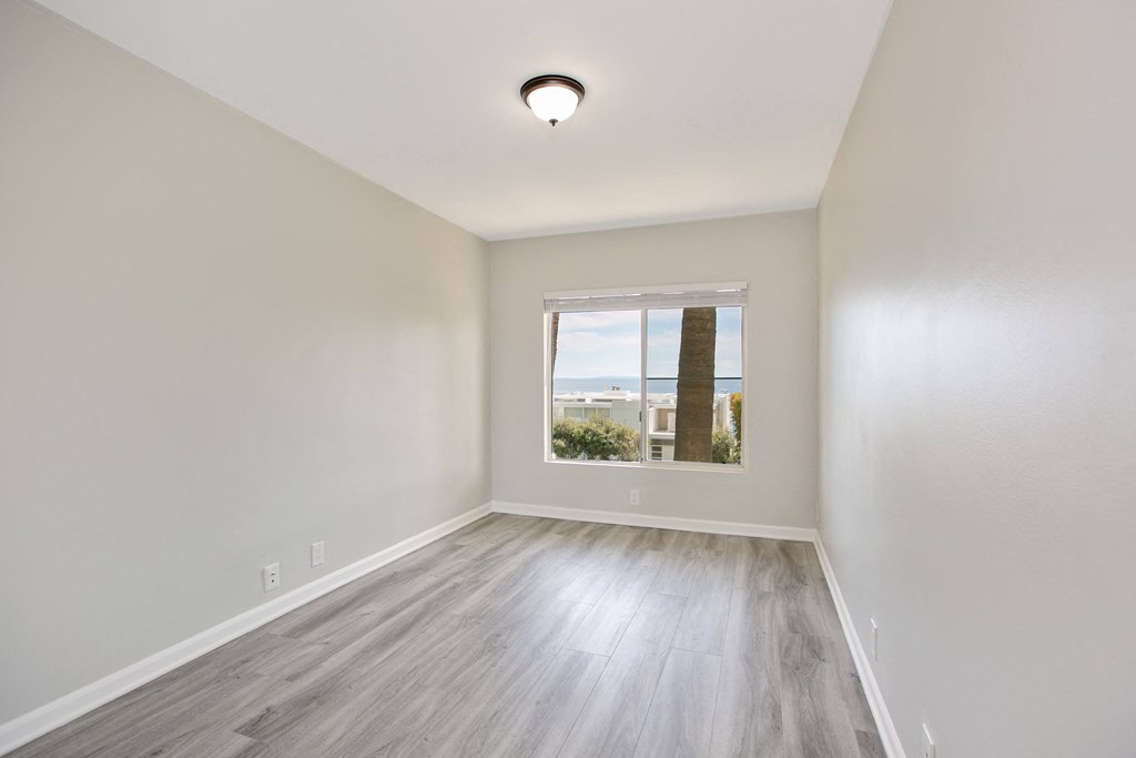 an empty room with white walls and a window