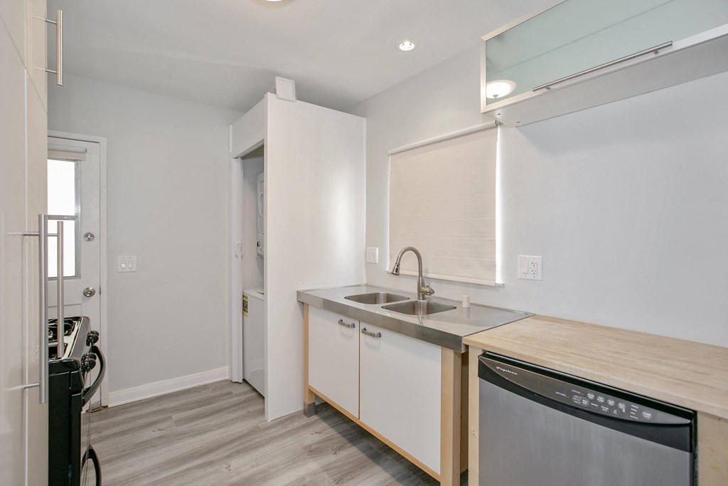 a kitchen with a sink and a dishwasher in a house