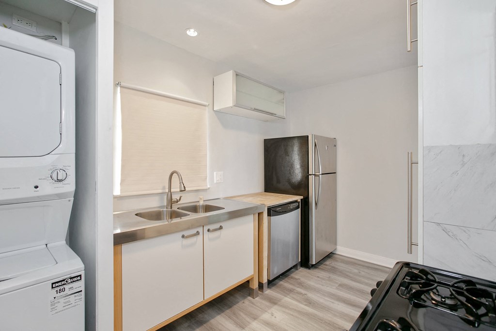 a kitchen with white cabinets and stainless steel appliances and a refrigerator