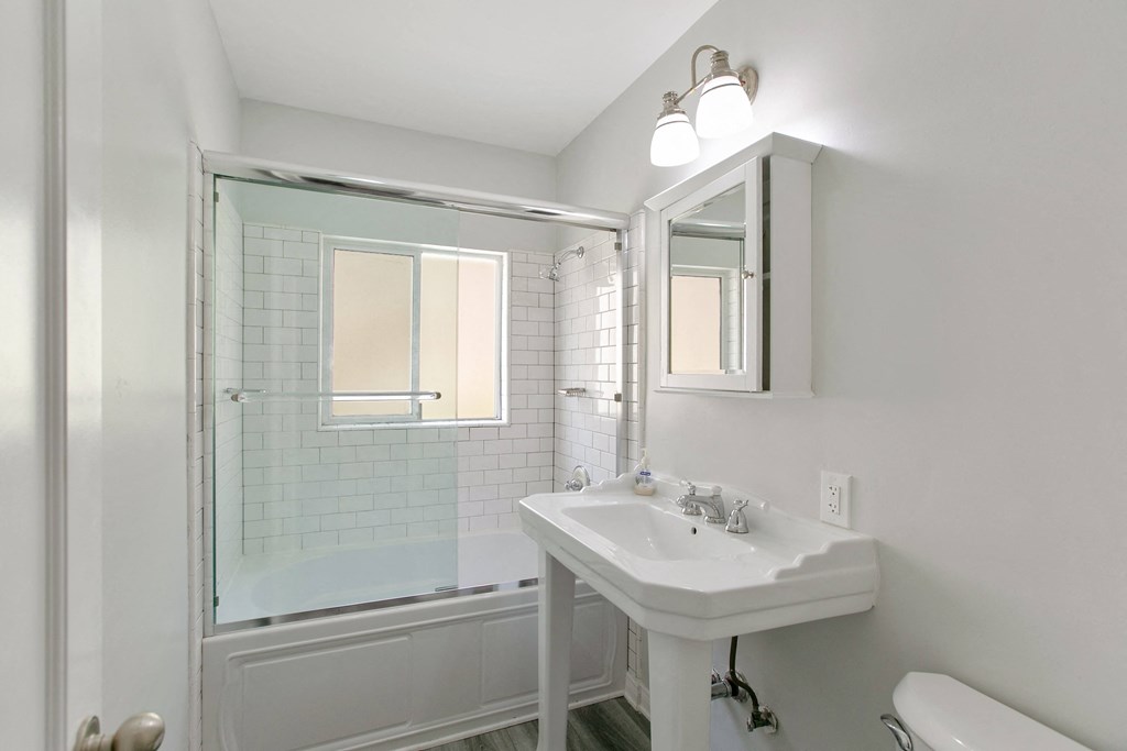 a white bathroom with a sink and a shower