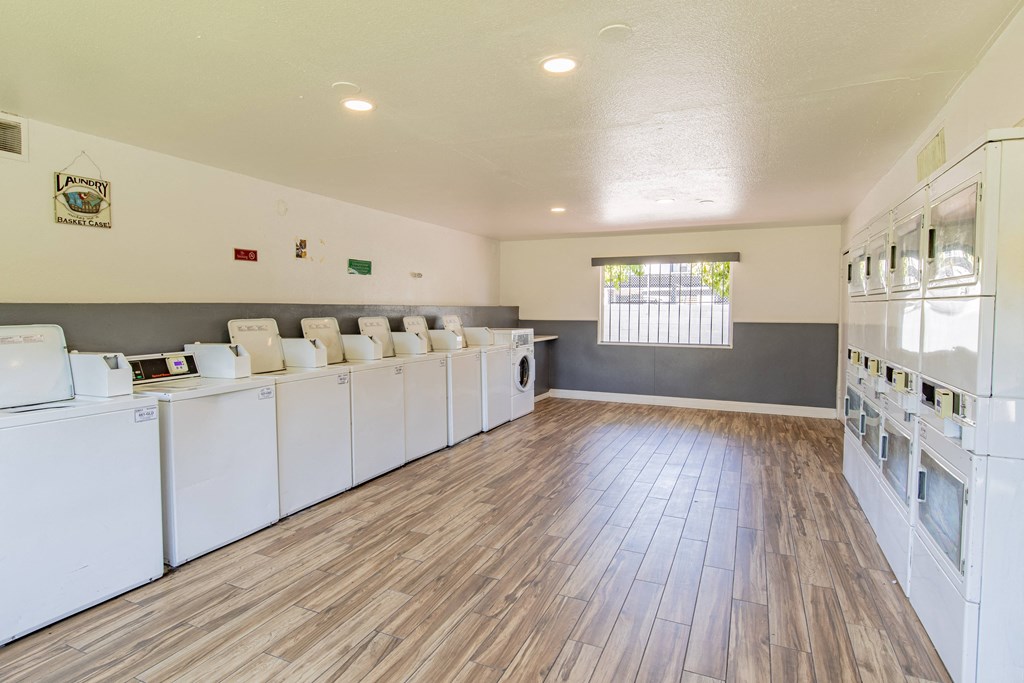 a community laundry room with washers and dryers and a wood floor