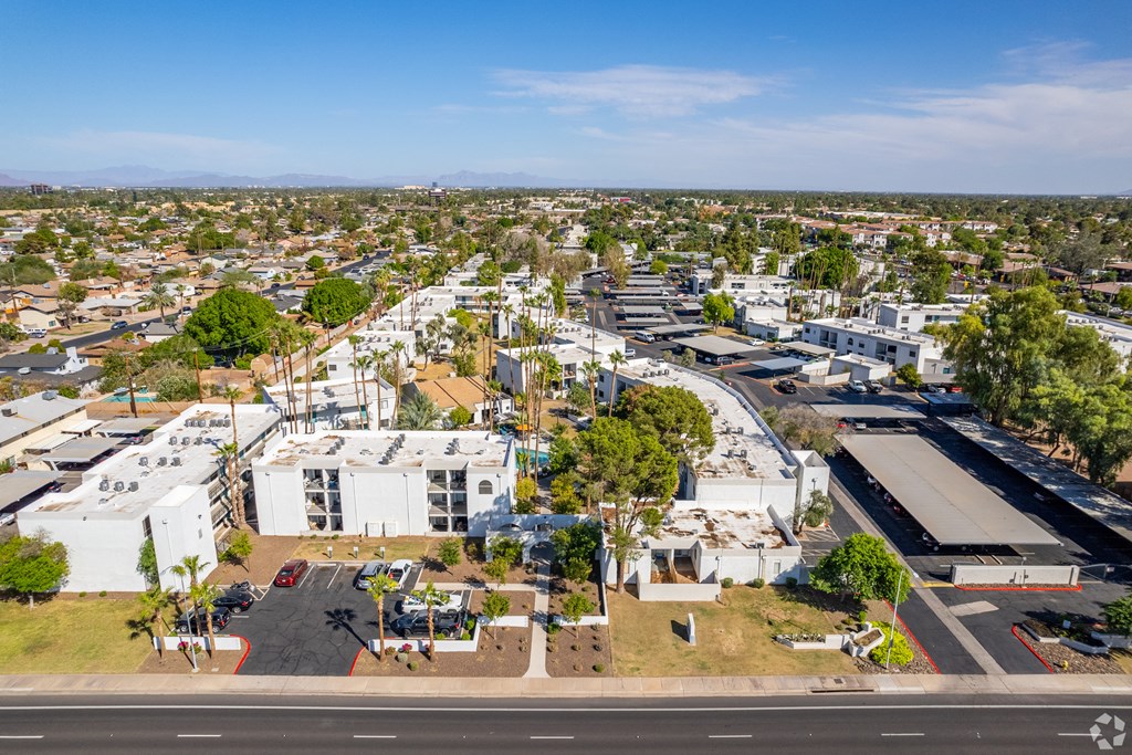 an aerial view of a city with white buildings and trees