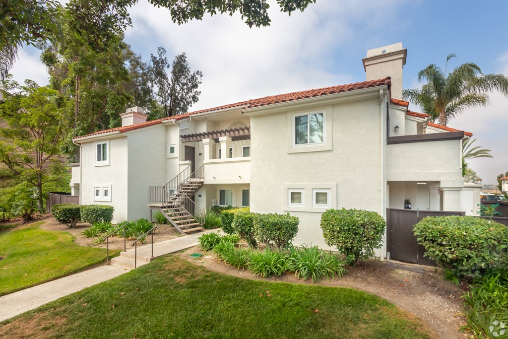 a white house with a yard and a staircase