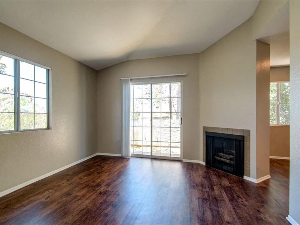 an empty living room with a fireplace and a large window