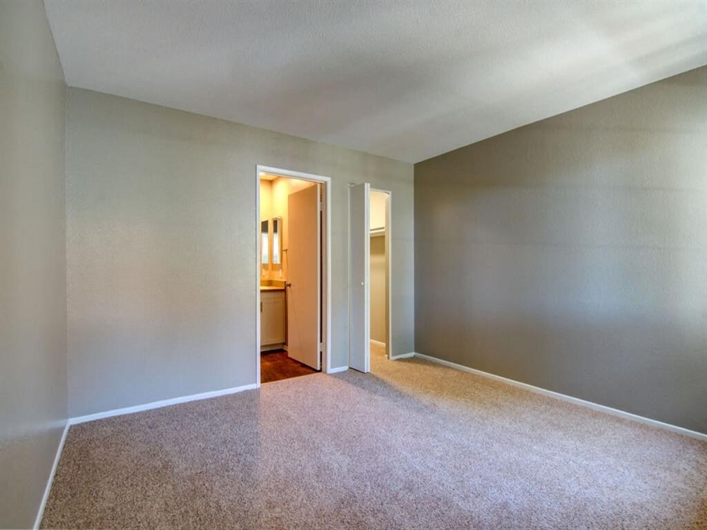 a large empty room with a doorway to a bathroom