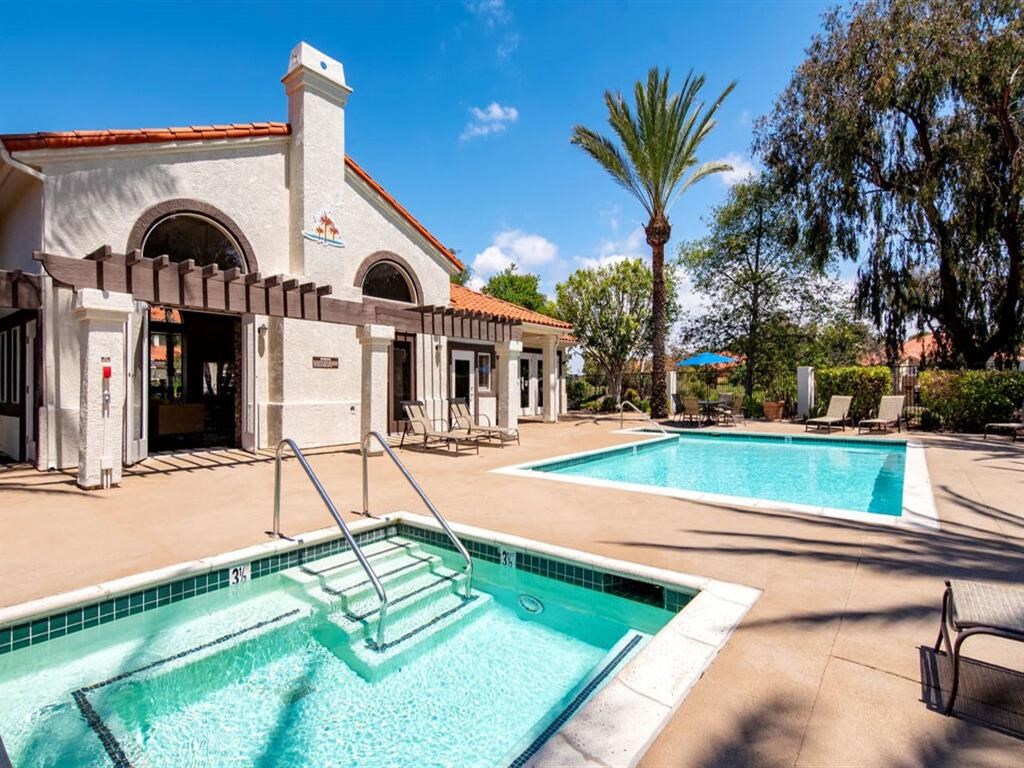 a swimming pool and hot tub in front of a building