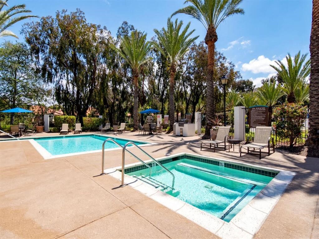 a swimming pool with palm trees and chairs around it