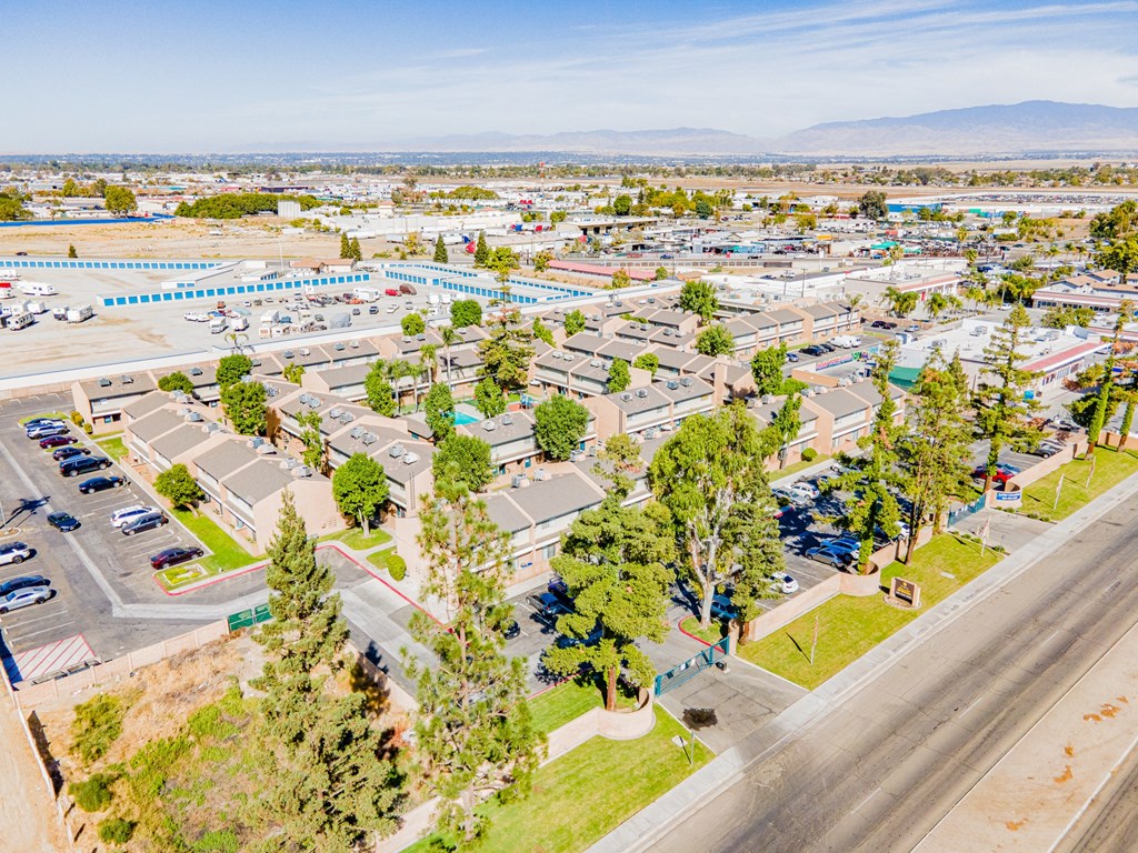 an aerial view of a parking lot with cars and trees
