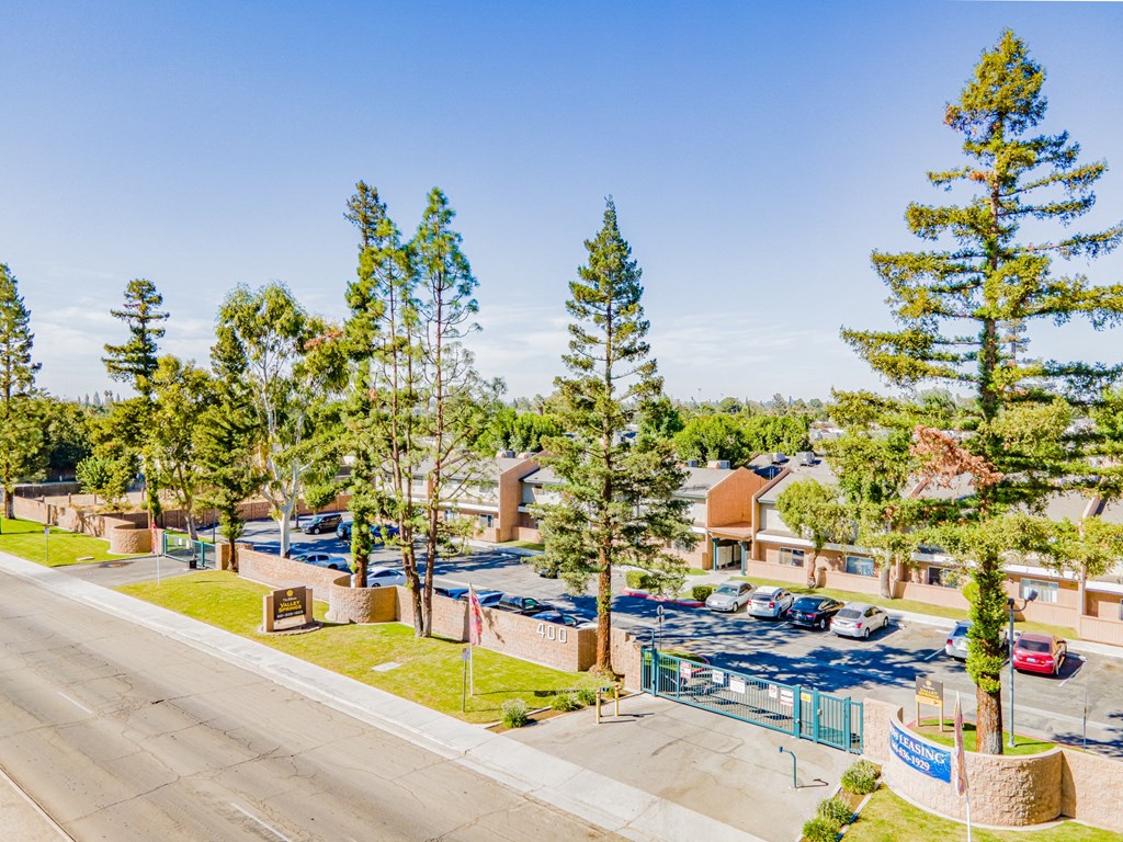 a view of a parking lot with trees and buildings